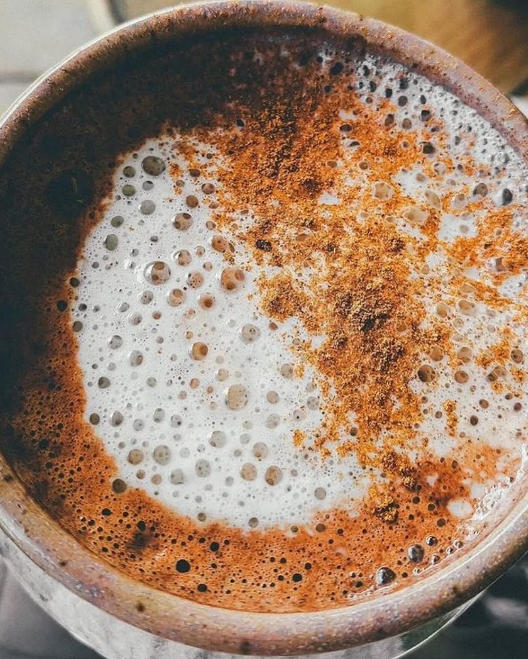 A close-up of frothy cacao in a ceramic cup